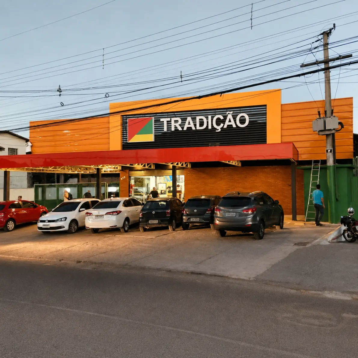 Fachada do supermercado Tradição com estacionamento em frente.