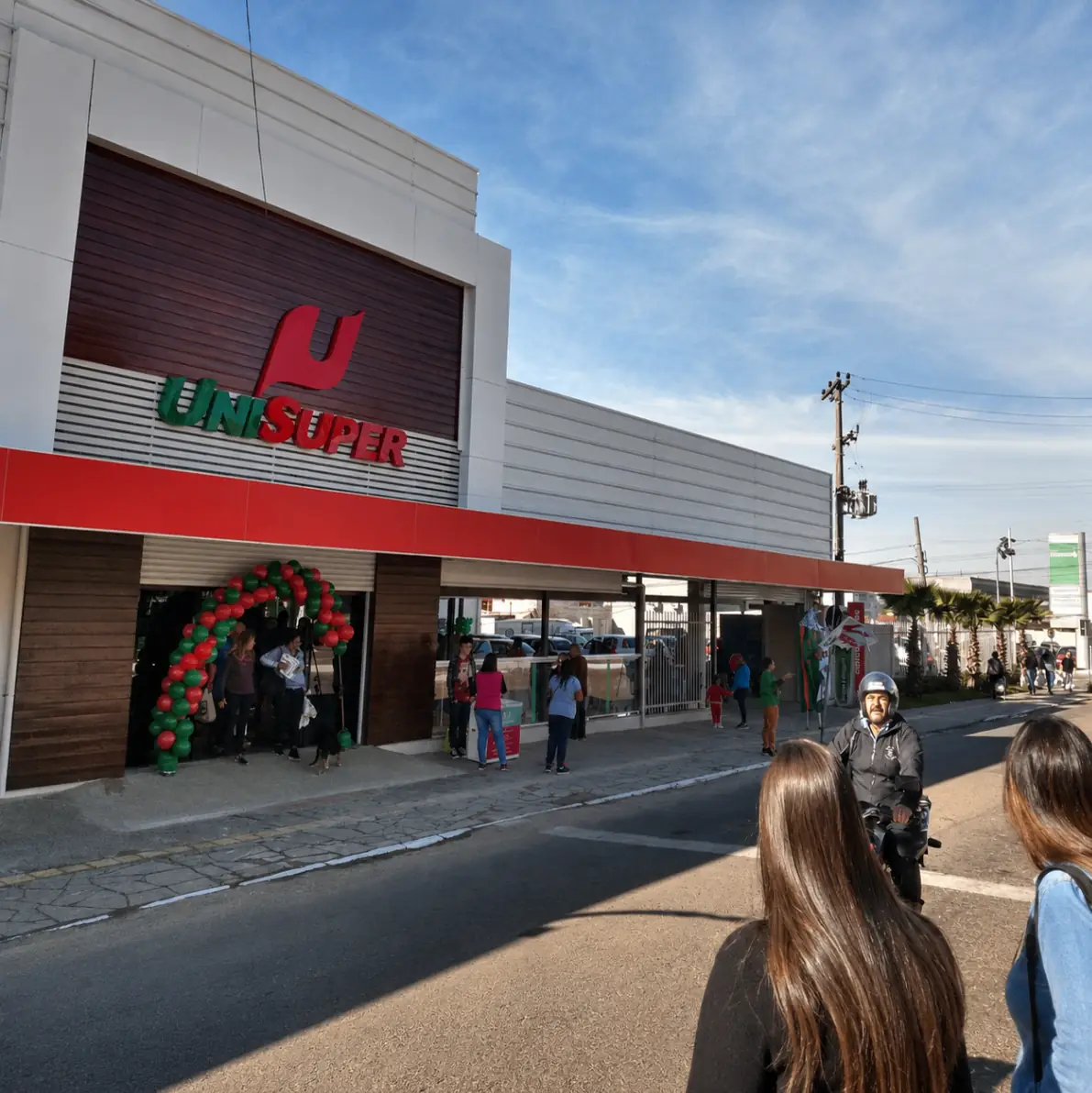 Fachada de supermercado UniSuper com fluxo de pessoas na entrada.